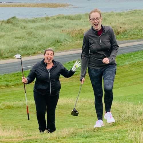 Women laughing together during a love.golf beginner golf session